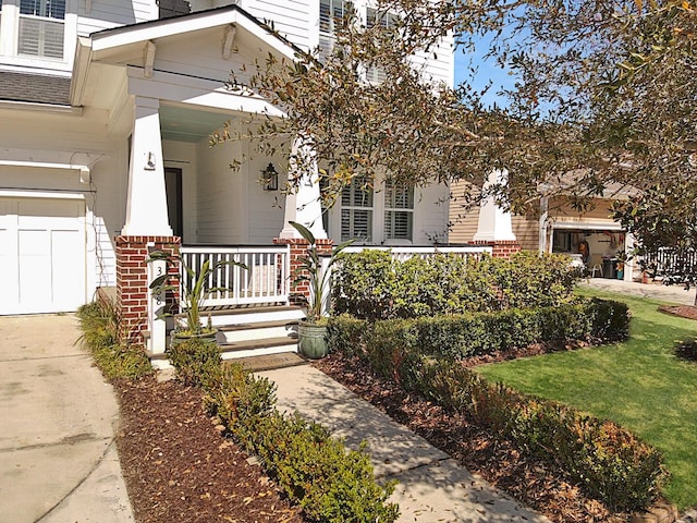 property entrance featuring brick siding, covered porch, and a shingled roof