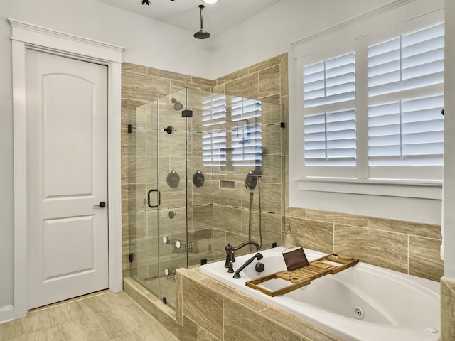 bathroom featuring a tub with jets and a stall shower