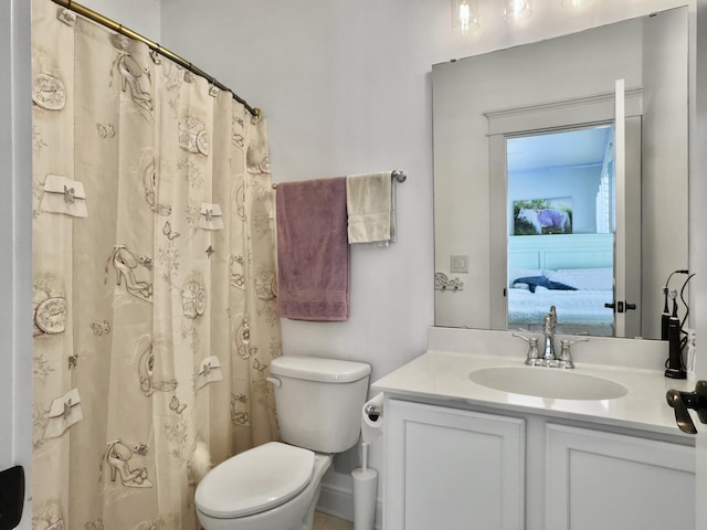 bathroom with a shower with shower curtain, vanity, toilet, and ensuite bathroom