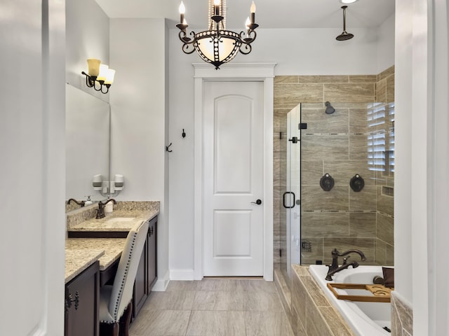 full bath featuring vanity, a bath, baseboards, a shower stall, and a notable chandelier