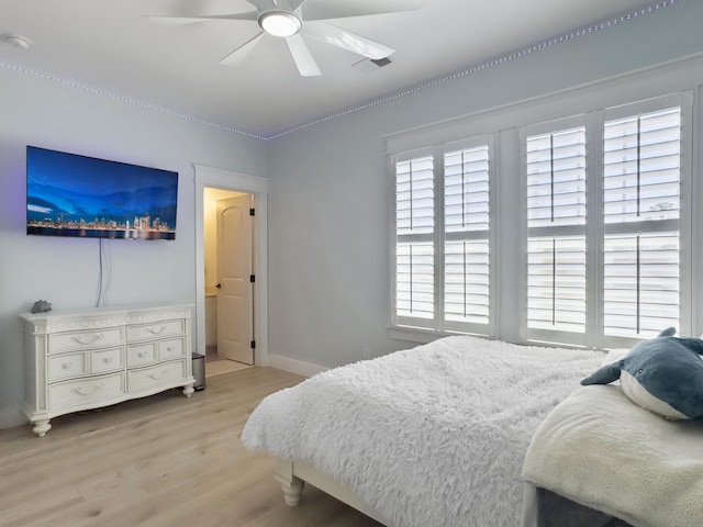 bedroom featuring baseboards, ceiling fan, and light wood finished floors