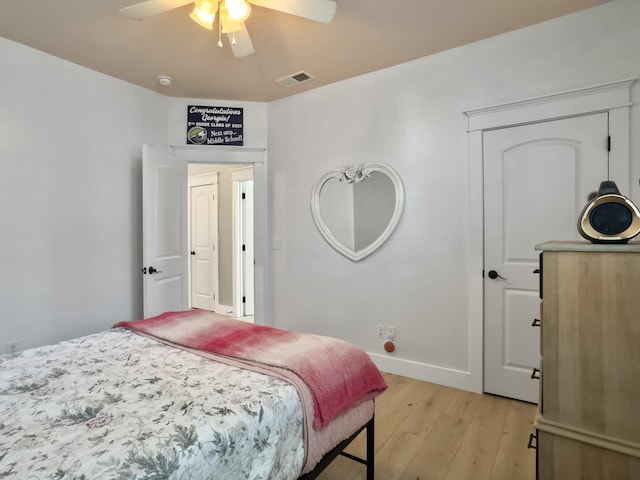 bedroom with light wood-type flooring, visible vents, baseboards, and a ceiling fan