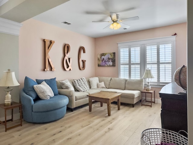 living area featuring light wood-style flooring, visible vents, and ceiling fan