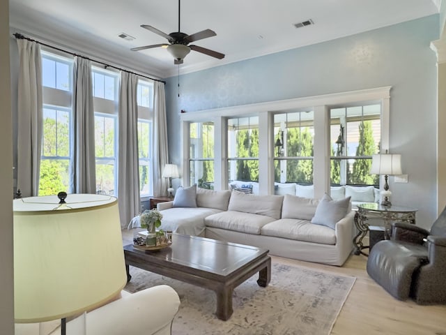 living room with visible vents, ornamental molding, a ceiling fan, and wood finished floors