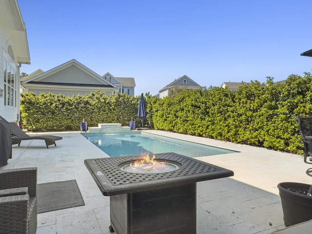 view of swimming pool featuring a fenced in pool, an outdoor fire pit, and a patio area