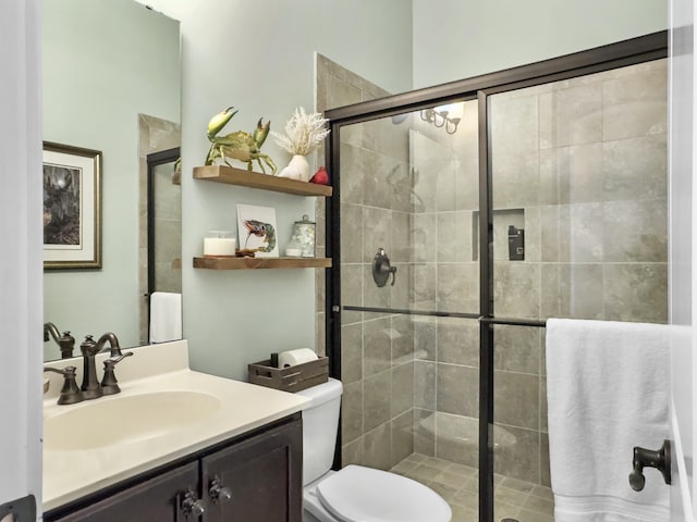 full bathroom featuring toilet, a stall shower, and vanity