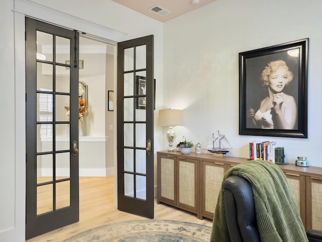 home office featuring light wood-style flooring, french doors, and visible vents