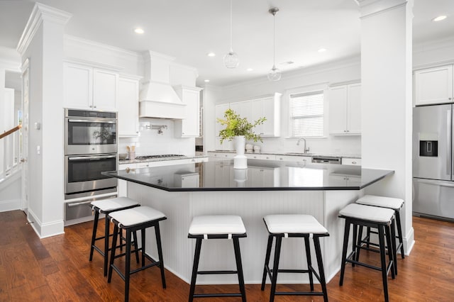 kitchen with white cabinetry, sink, a kitchen breakfast bar, and appliances with stainless steel finishes