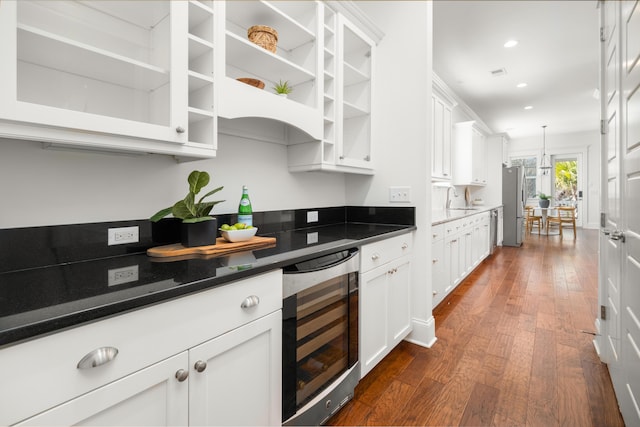 kitchen with dark hardwood / wood-style floors, stainless steel refrigerator, white cabinetry, sink, and wine cooler