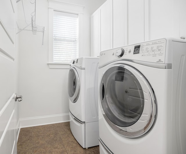 laundry area featuring dark tile patterned floors and washer and clothes dryer