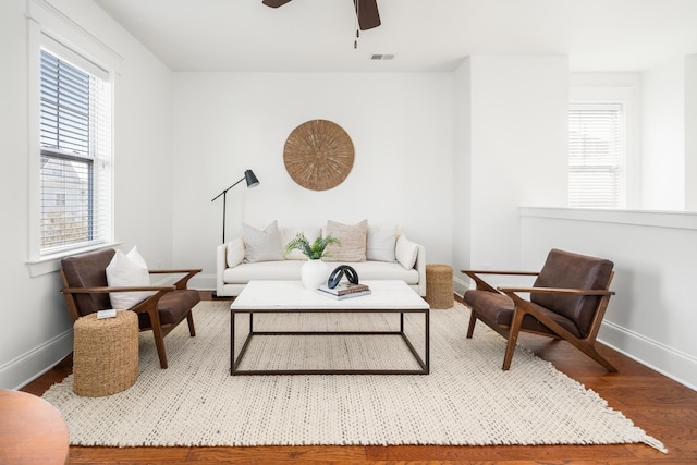 living room featuring ceiling fan and dark hardwood / wood-style floors