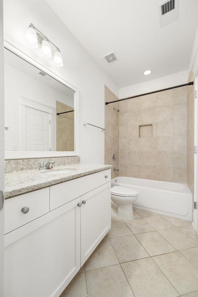 full bathroom with tiled shower / bath, tile patterned floors, toilet, and vanity