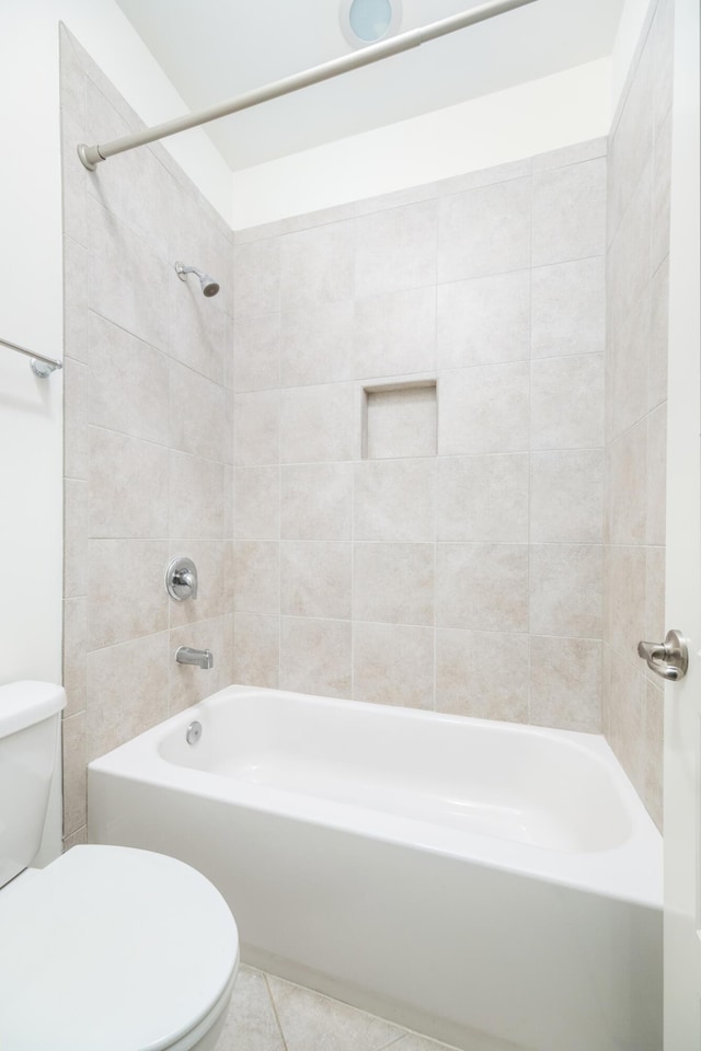 bathroom featuring tiled shower / bath combo, tile patterned floors, and toilet