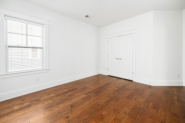 unfurnished bedroom with wood-type flooring and a closet