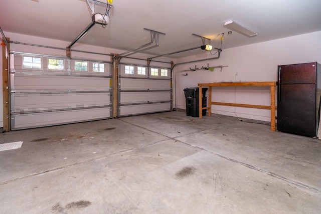 garage featuring black refrigerator and a garage door opener