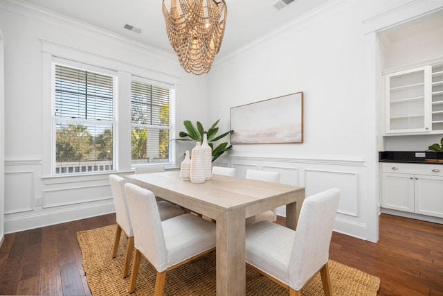 dining area with ornamental molding, dark hardwood / wood-style floors, and a chandelier