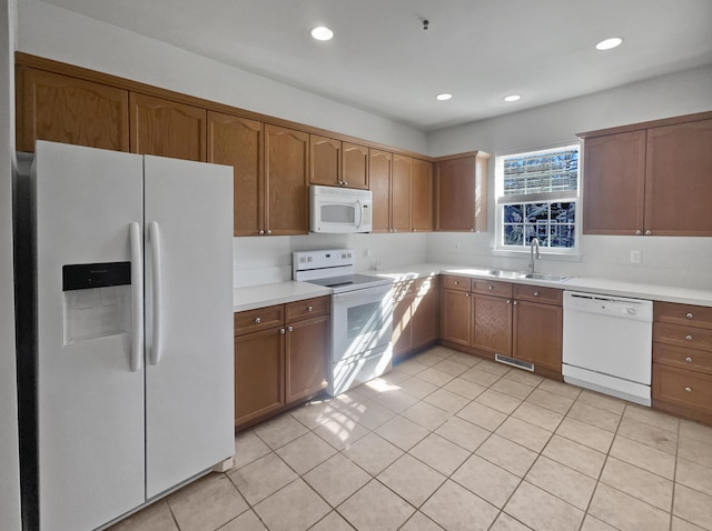 kitchen featuring sink, white appliances, and light tile patterned floors