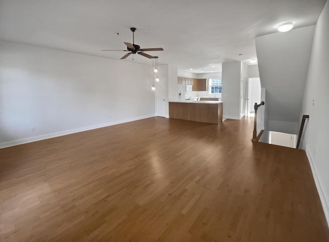 unfurnished living room with ceiling fan and dark hardwood / wood-style flooring