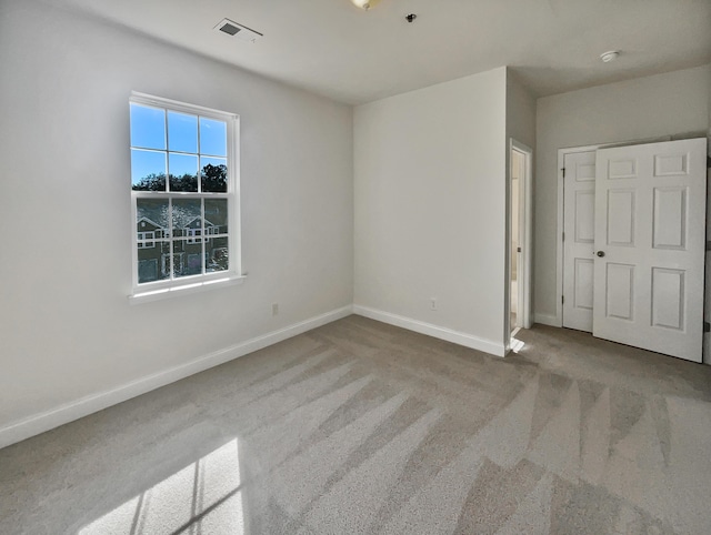 unfurnished bedroom featuring a closet and light carpet