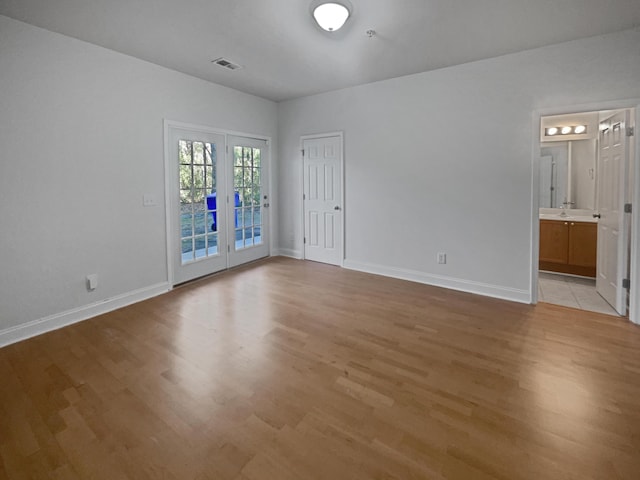 spare room featuring light hardwood / wood-style floors, sink, and french doors