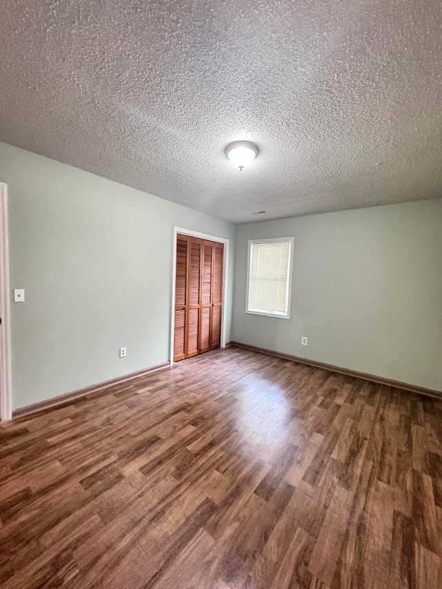 unfurnished room with a textured ceiling and hardwood / wood-style floors