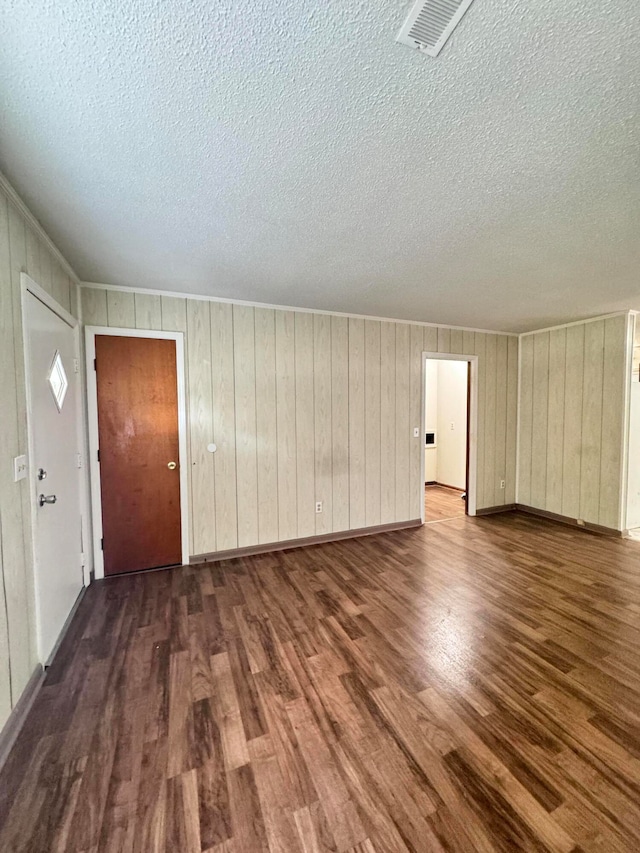 bonus room featuring wood walls, a textured ceiling, and hardwood / wood-style flooring