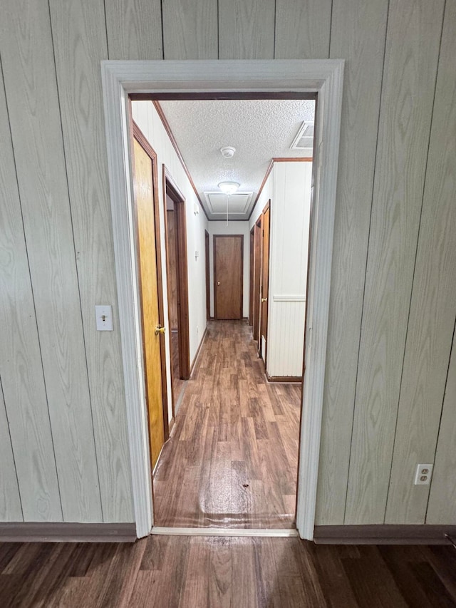 corridor featuring a textured ceiling and hardwood / wood-style flooring