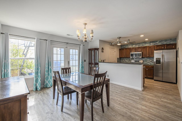 dining room featuring ceiling fan with notable chandelier and light wood-type flooring