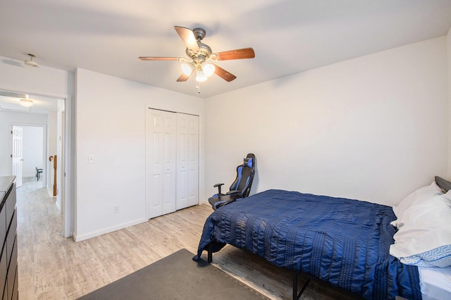 bedroom featuring ceiling fan, light wood-type flooring, and a closet