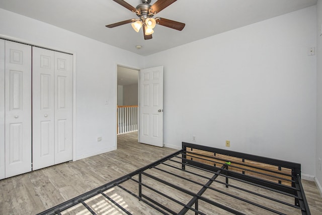 bedroom with hardwood / wood-style floors, ceiling fan, and a closet