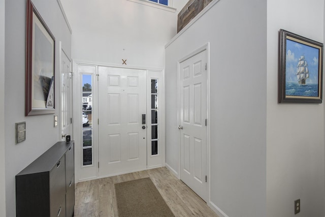 entrance foyer featuring a towering ceiling and light hardwood / wood-style flooring