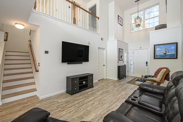 living room featuring a notable chandelier and light wood-type flooring