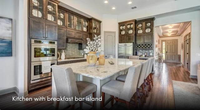 629 Marsh Cove Cir, Summerville, SC 29486 - kitchen featuring appliances with stainless steel finishes, backsplash, a center island, dark wood-style floors, and light stone counters