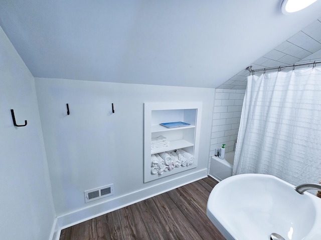 837 Club Cottage Rd, Edisto Island, SC 29438 - bathroom featuring built in features, wood finished floors, vaulted ceiling, and shower / bathtub combination with curtain
