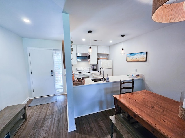 837 Club Cottage Rd, Edisto Island, SC 29438 - kitchen featuring white appliances, dark wood-style flooring, a peninsula, white cabinetry, and recessed lighting