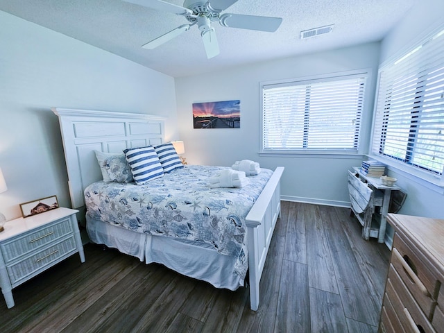 837 Club Cottage Rd, Edisto Island, SC 29438 - bedroom featuring dark wood-style flooring, multiple windows, a textured ceiling, and a ceiling fan