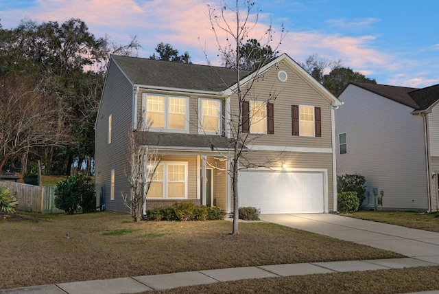 traditional-style home featuring a garage, a front yard, driveway, and fence