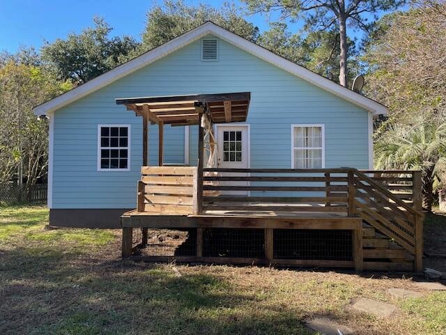 rear view of house featuring a lawn and a deck