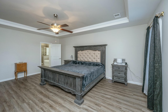 bedroom featuring ceiling fan, crown molding, hardwood / wood-style flooring, and a tray ceiling