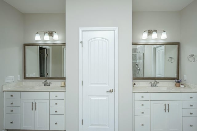 bathroom featuring a shower with door and vanity