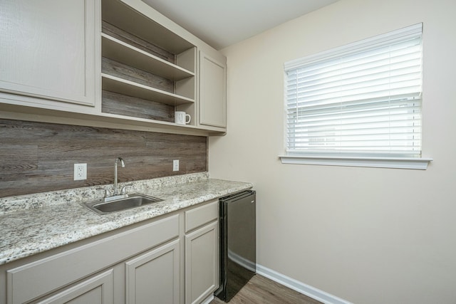 kitchen featuring sink, backsplash, light stone countertops, and dark wood-type flooring