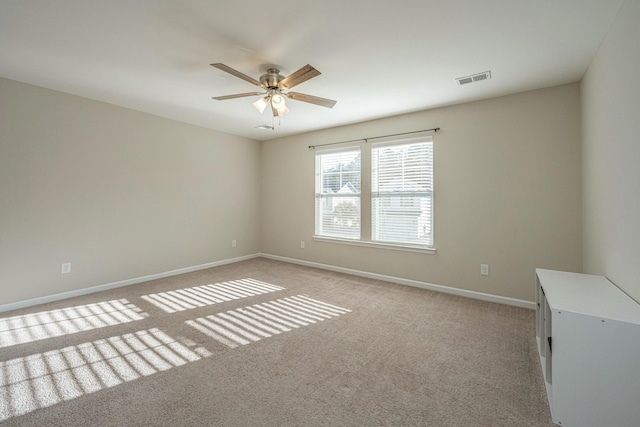 unfurnished room with ceiling fan and light carpet