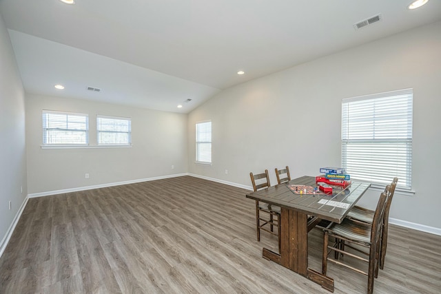 dining space featuring vaulted ceiling and hardwood / wood-style flooring