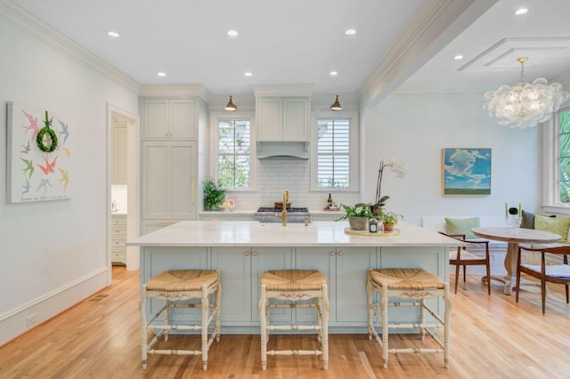 62 Eastlake Rd, Mount Pleasant, SC 29464 - kitchen with plenty of natural light, ornamental molding, tasteful backsplash, light countertops, and light wood-type flooring