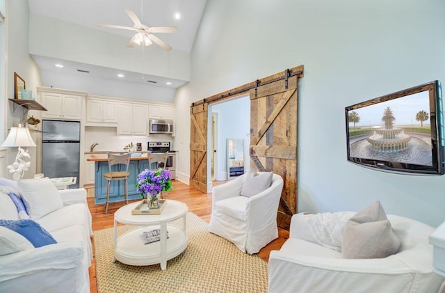 62 Eastlake Rd, Mount Pleasant, SC 29464 - living area with a barn door, light wood finished floors, ceiling fan, recessed lighting, and high vaulted ceiling