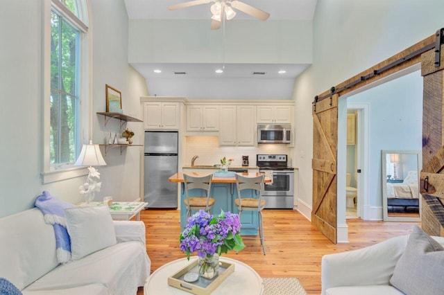 62 Eastlake Rd, Mount Pleasant, SC 29464 - living area featuring a barn door, healthy amount of natural light, light wood-type flooring, ceiling fan, and recessed lighting