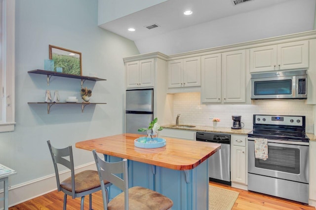 62 Eastlake Rd, Mount Pleasant, SC 29464 - kitchen featuring stainless steel appliances, butcher block counters, a sink, light wood-type flooring, and backsplash