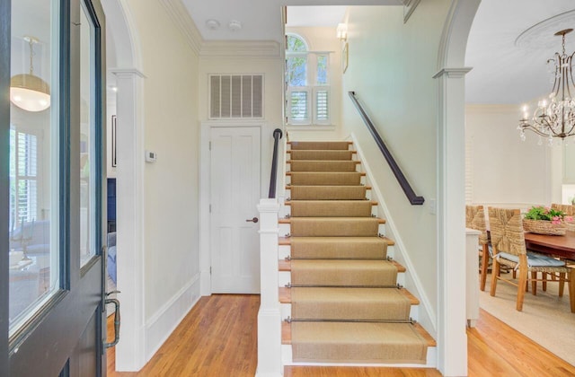 62 Eastlake Rd, Mount Pleasant, SC 29464 - foyer with light wood-style flooring, a chandelier, arched walkways, stairway, and ornamental molding
