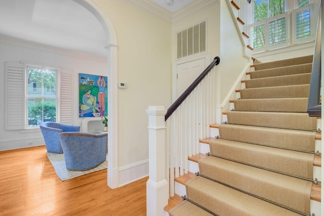 62 Eastlake Rd, Mount Pleasant, SC 29464 - stairs with arched walkways, wood finished floors, crown molding, and baseboards