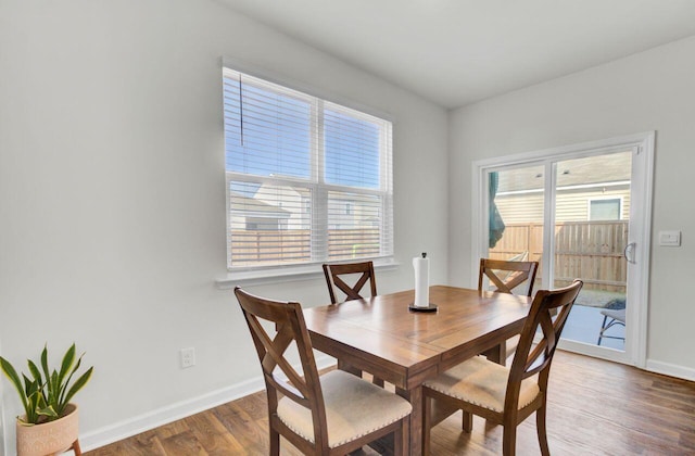 dining space with plenty of natural light, baseboards, and wood finished floors